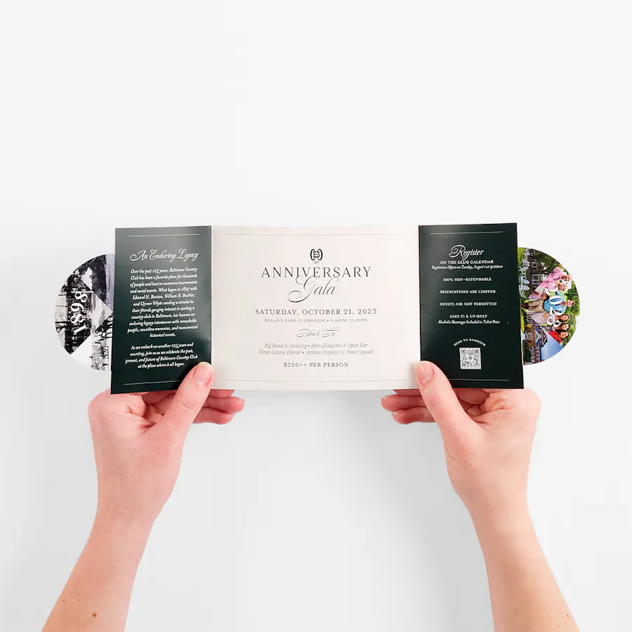 Two hands holding open a circle locked gate invite printed with gala details.