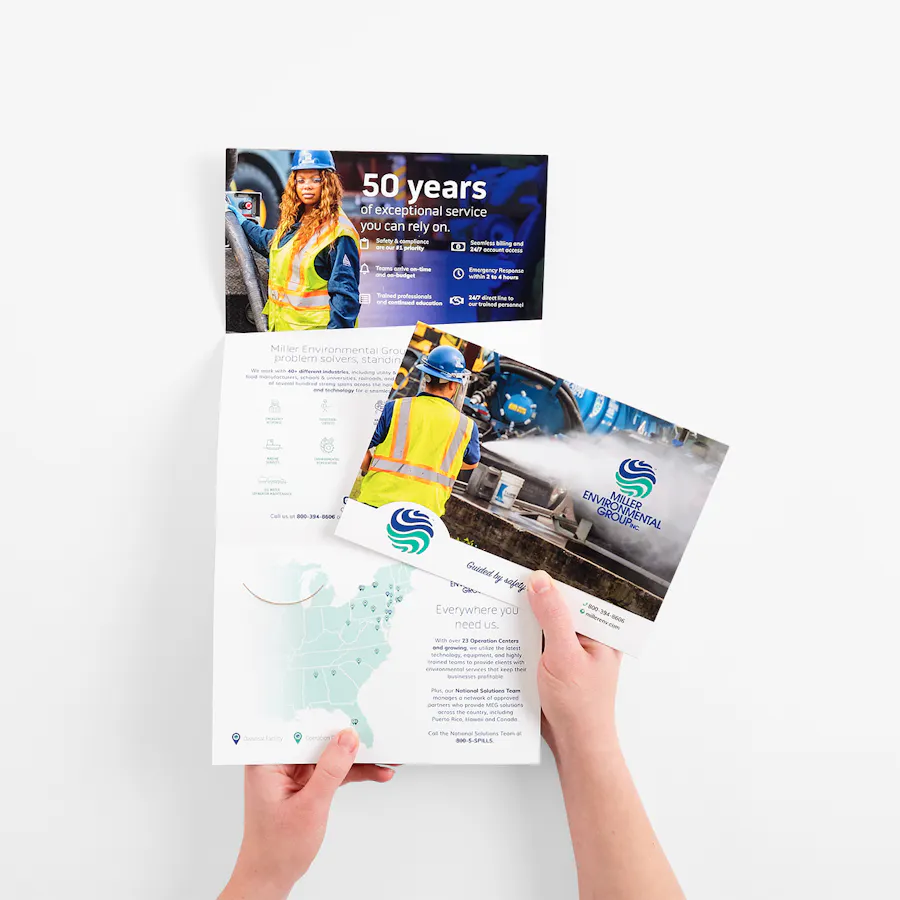 Two hands holding to tri fold brochures printed with business and service information.