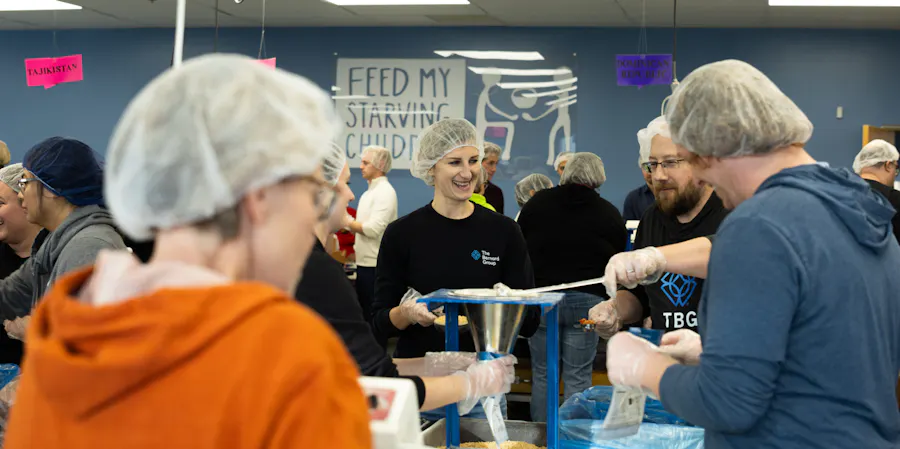 A room full of people packing food into bags and boxes for Feed My Starving Children.