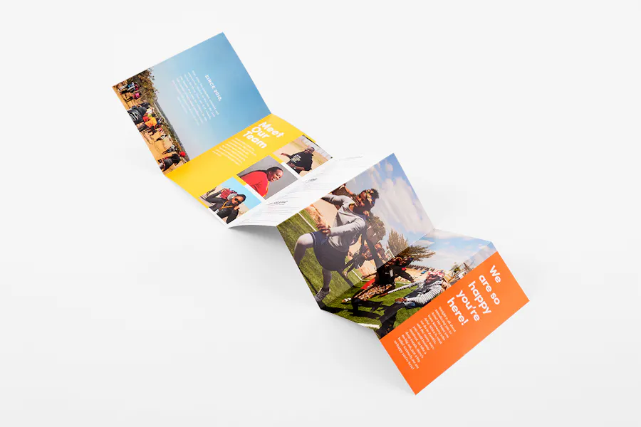A custom brochure laying unfolded with an accordion format and printed with a blue, yellow and orange design.