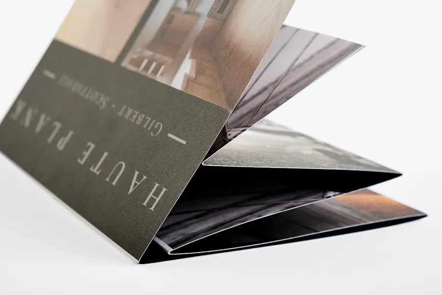 A wrapped stepped accordion fold brochure printed with Haute Plane on the cover.