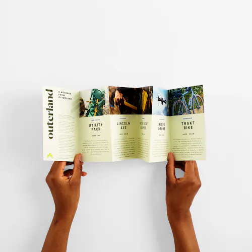 Two hands holding an accordion fold brochure with six panels and images of outdoor gear.