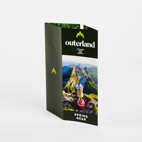 A closed gate fold brochure printed with Outerland Spring Gear on the front.