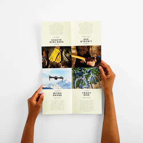 Two hands holding a product brochure printed with a double fold.