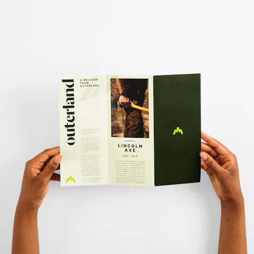 Z-Fold Two hands holding open a Z fold brochure printed with Outerland and details about an axe.
