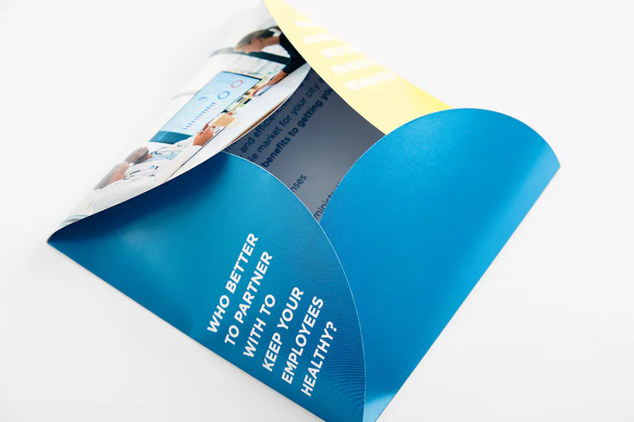 A square petal sales brochure unfolding and printed with a blue, yellow and white design.