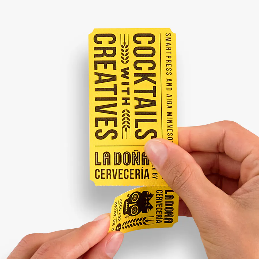 Two hands holding a custom event ticket printed with Cocktails with Creatives in black and yellow and a perforated ticket.