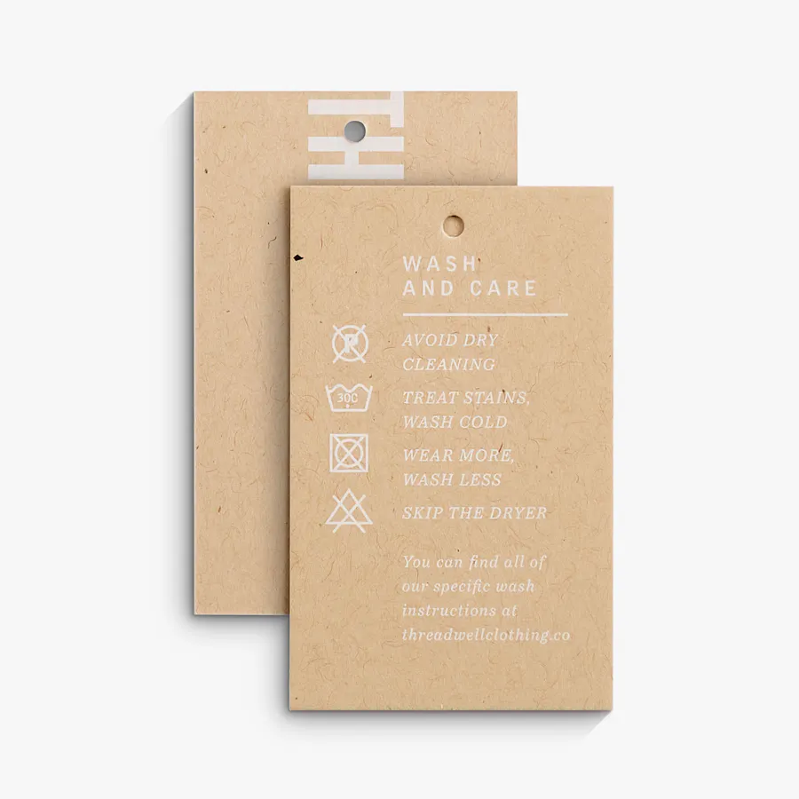 Two clothing hang tags overlapping each other and printed on Kraft paper with wash and care instructions in white.