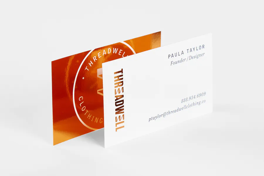 Two custom business cards printed with Threadwell contact info and an orange and white design.