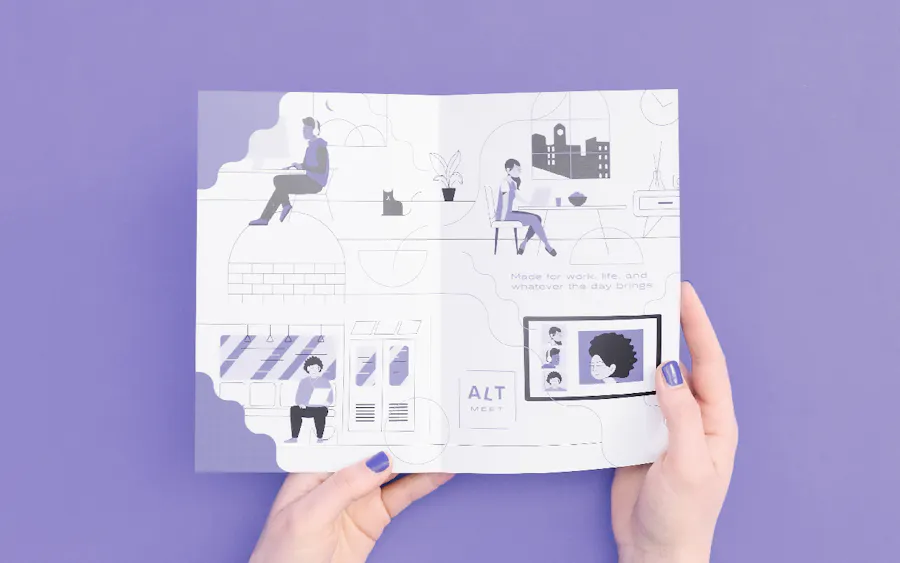 Two hands holding open a brochure printed with hand-drawn graphics in gray and light purple.