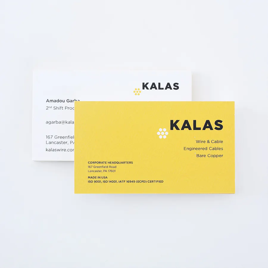 Two business cards overlapping each other and printed with a white and yellow design and Kalas in the top corner.