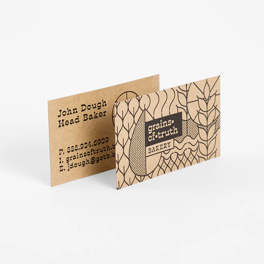 Two Kraft business cards overlapping each other and printed with Grains of Truth Bakery.