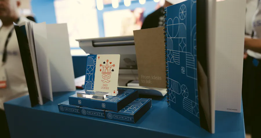 The Smartpress exhibition booth design for Adobe MAX, with a table full of custom playing cards and notebooks.