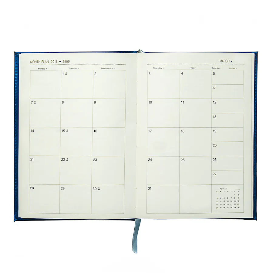 A custom planner with a tassel bookmark laying flat and open to a view of the whole month.