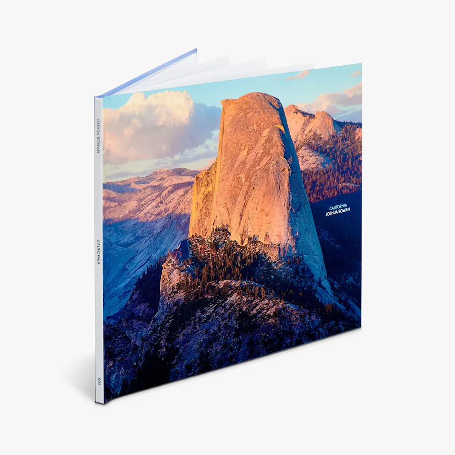A hardcover book standing open with a mountain landscape image on the cover.