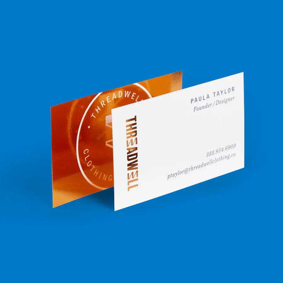 Two custom business cards overlapping each other and printed with Threadwell in orange.
