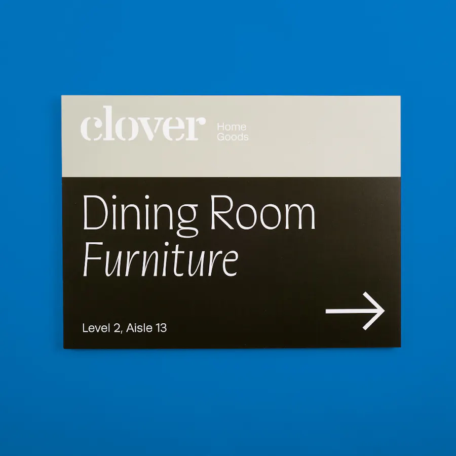 A custom sign printed with Clover Home Goods and Dining Room Furniture in tan and black.