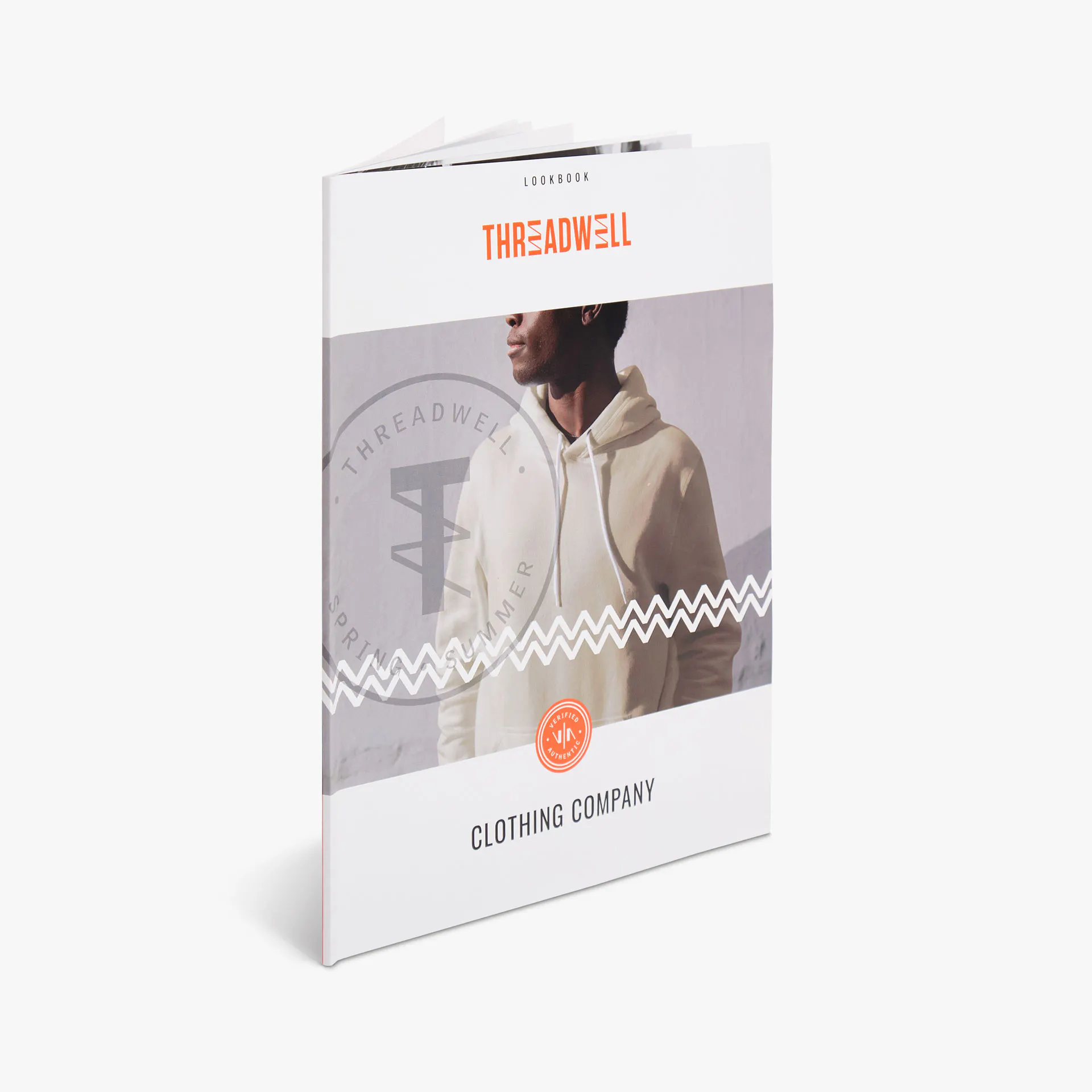 A direct mail catalog printed with Threadwell Clothing Company and a man wearing a cream hoodie.