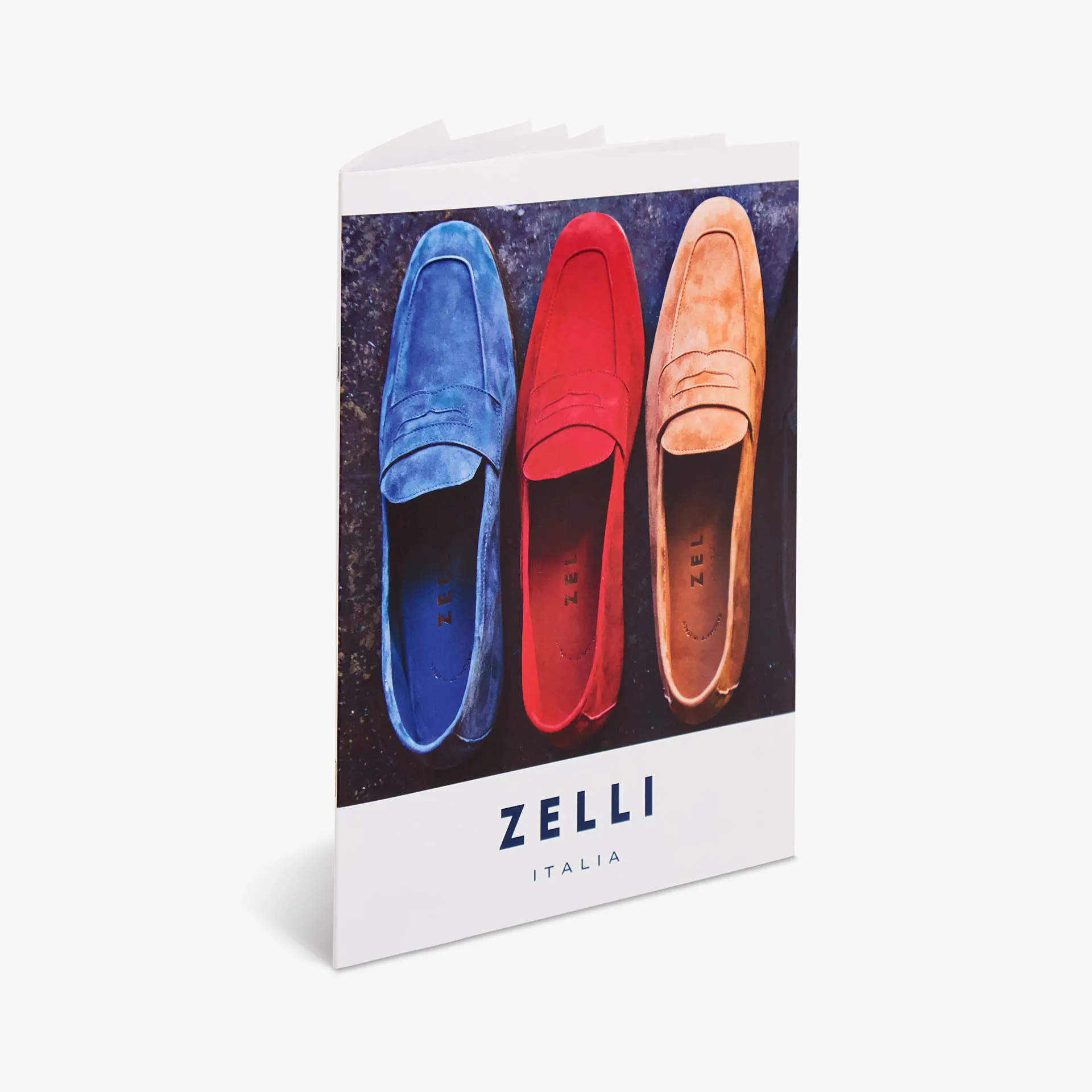 A saddle stitch booklet standing open and printed with Zelli Italia and an image of three loafers.