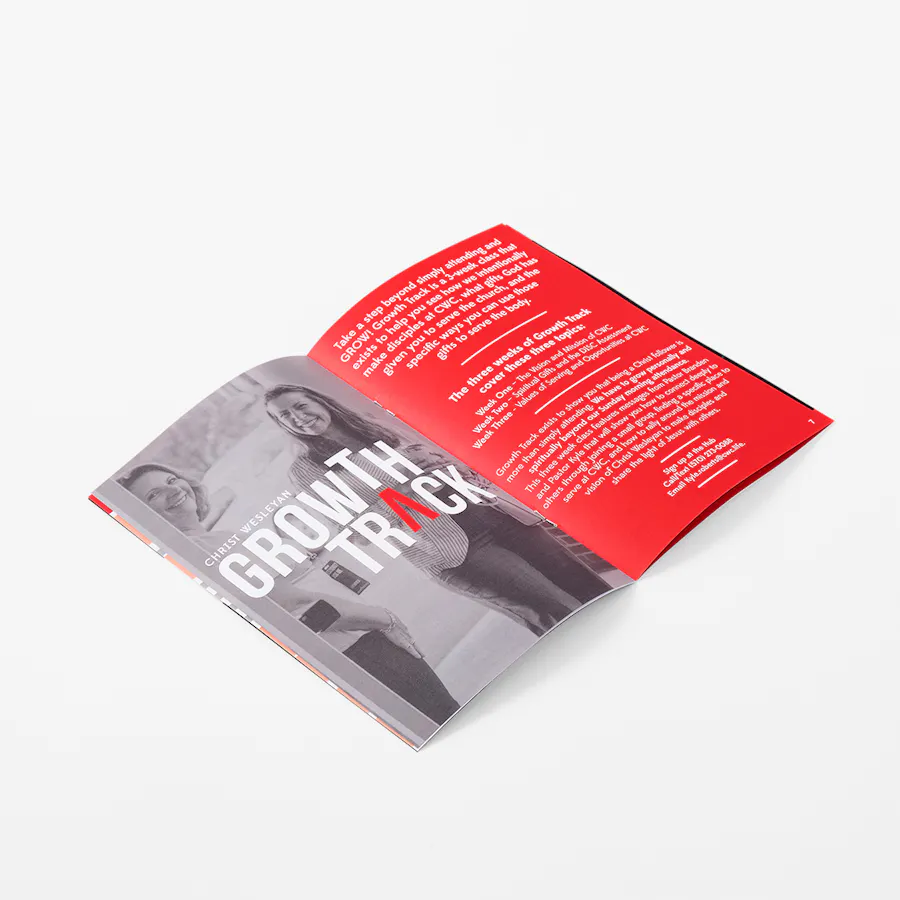 A magazine laying open to an image of two women and Growth Track in white and red.