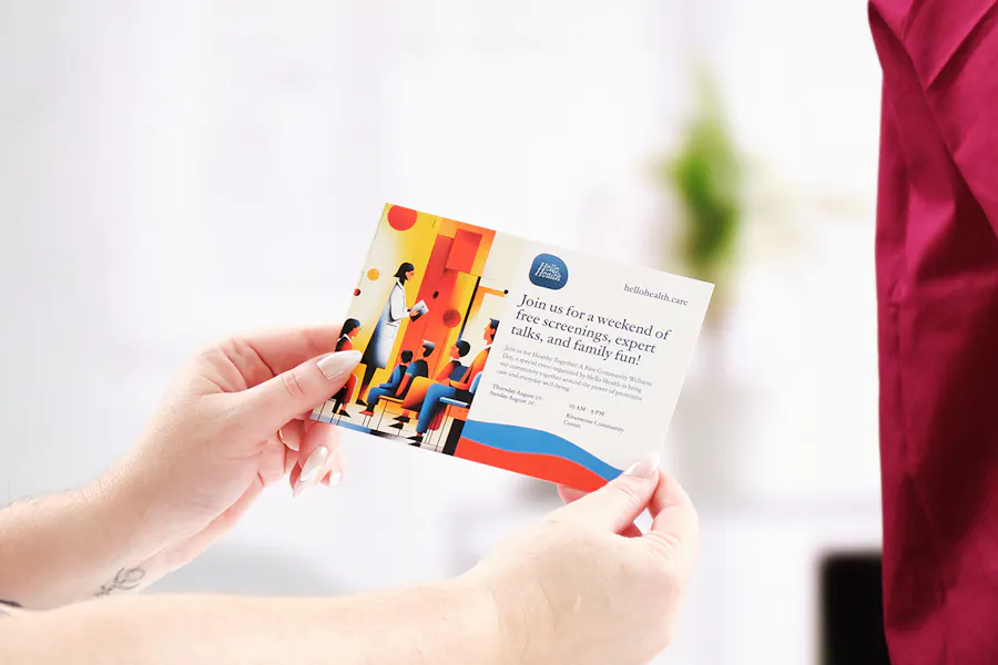 Two hands holding a health care postcard printed with info about free screenings.