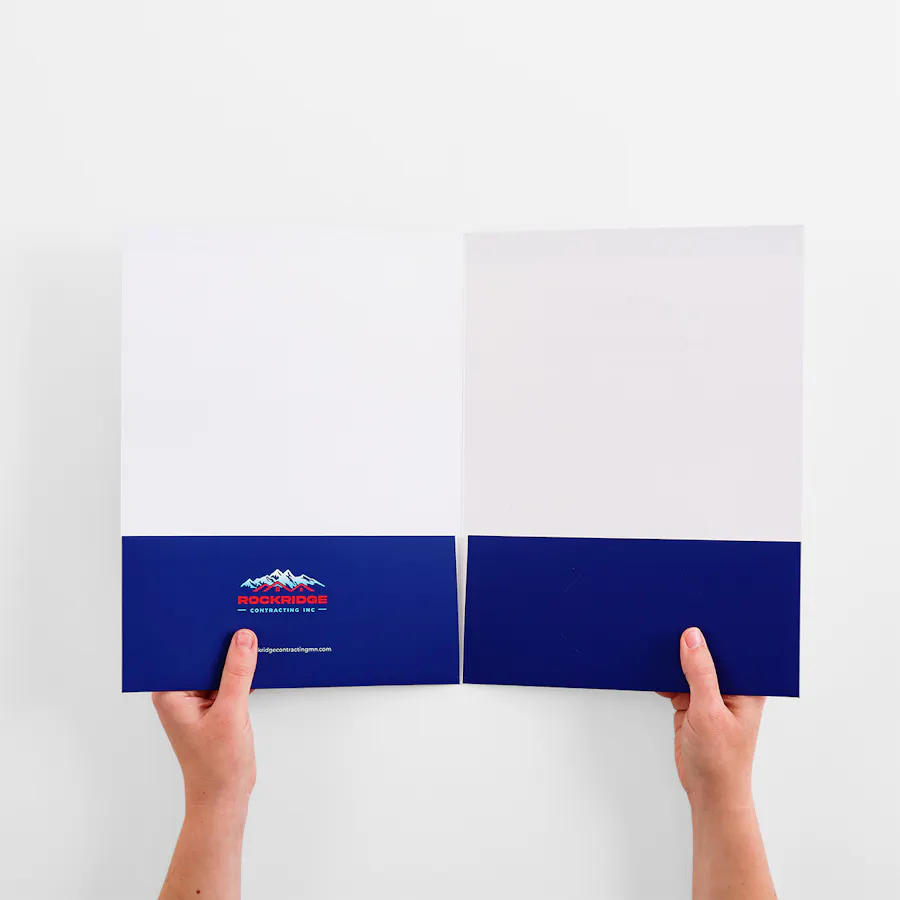 Two hands holding open a presentation folder with dark blue pockets.