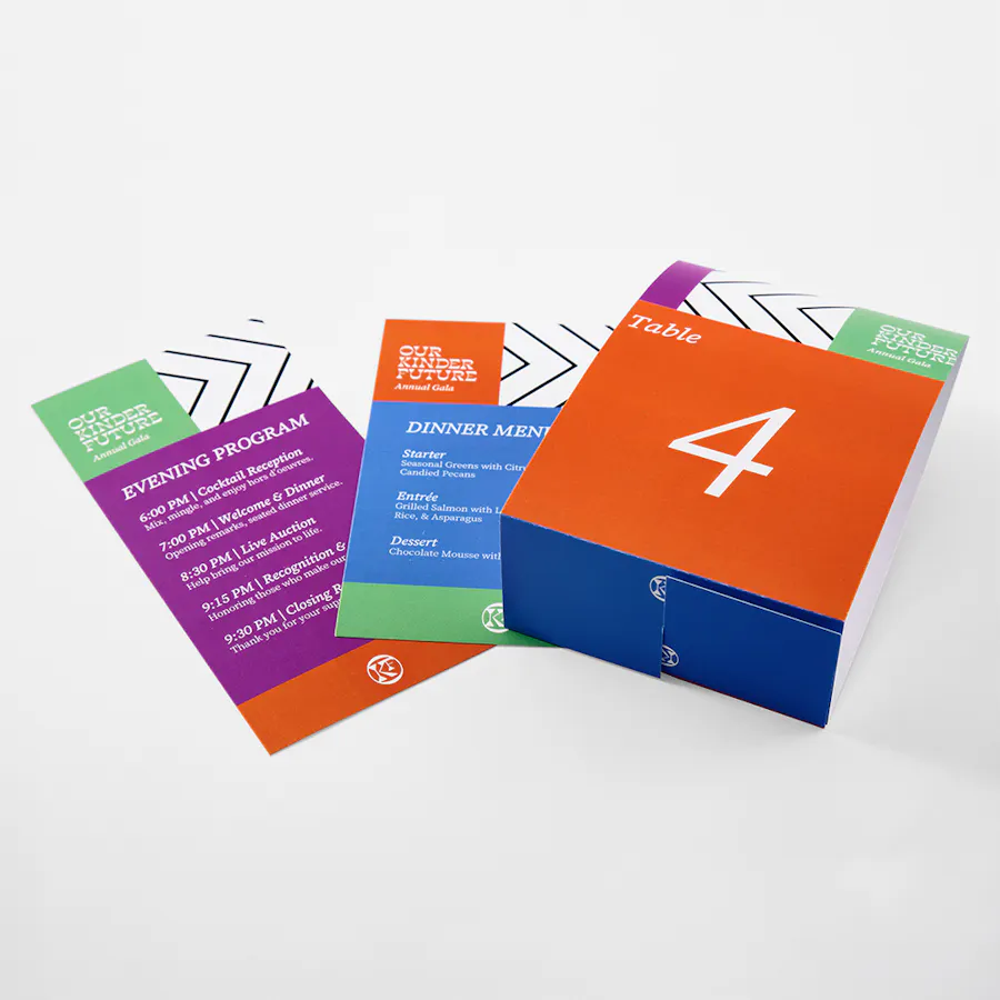 A brochure, menu and table tent printed for a nonprofit in orange, purple, blue and green.