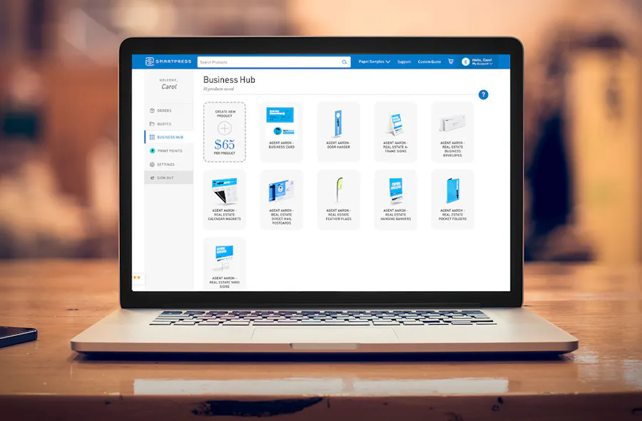 A laptop sitting on a table showing Smartpress' Business Hub landing page.