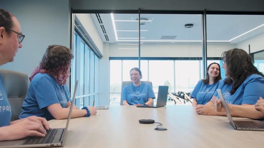 Five Smartpress employees sitting at a conference table in their new online printing facility.