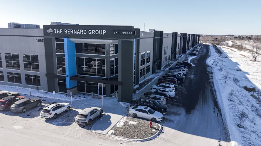 The outside of a blue, black and gray building, with The Bernard Group and Smartpress names at the top.