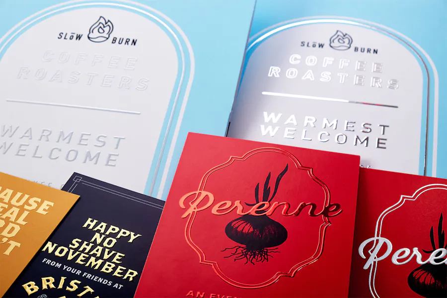 Pocket folders, invitations and cards printed with various marketing designs and raised foil accents.