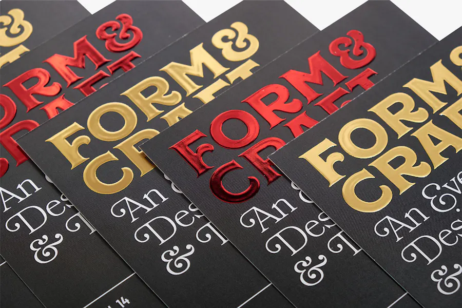 Five fanned out custom invitations printed with raised foil in red and gold.
