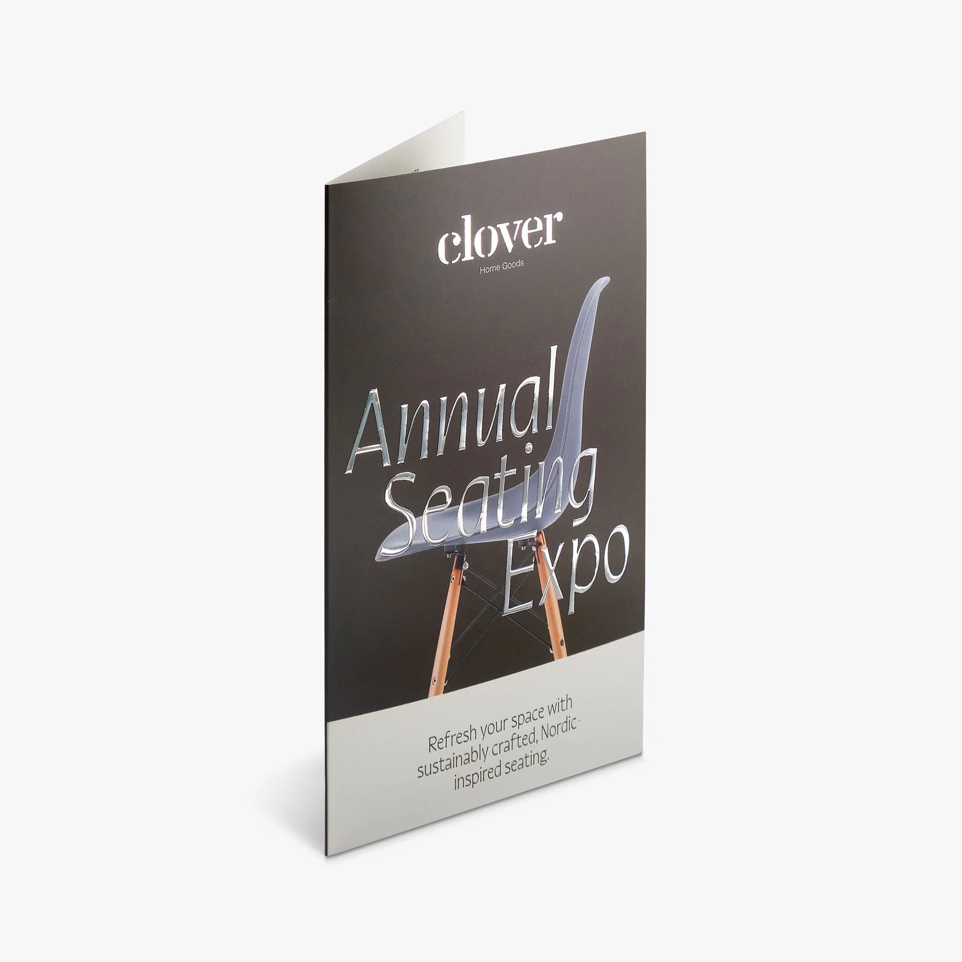 A raised foil brochure standing open with silver raised foil accents on the front.