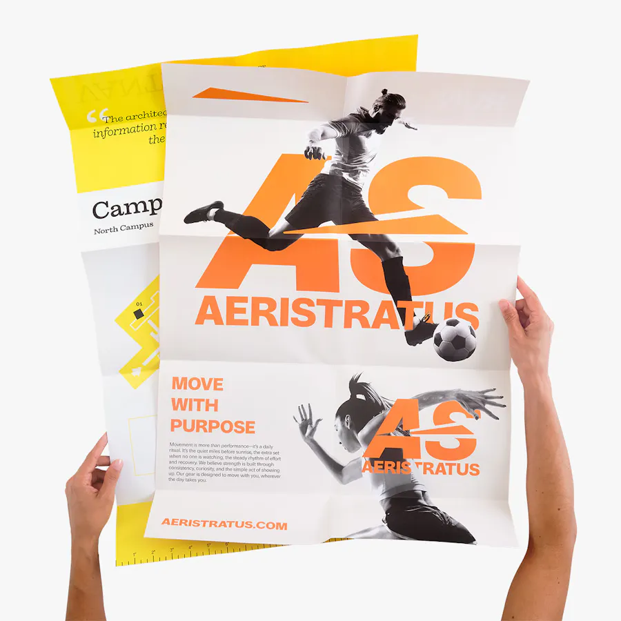 Two hands holding unfolded accordion-into-gate posters printed in yellow, orange and white.